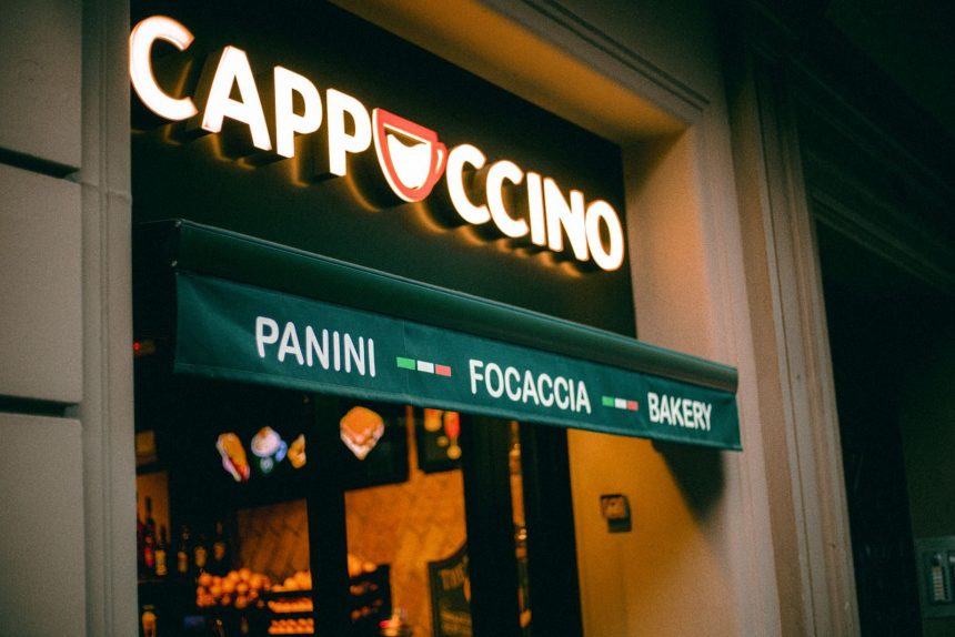 Warm-toned Italian cafe entrance with glowing sign and menu awning for Panini, Focaccia, and Bakery.