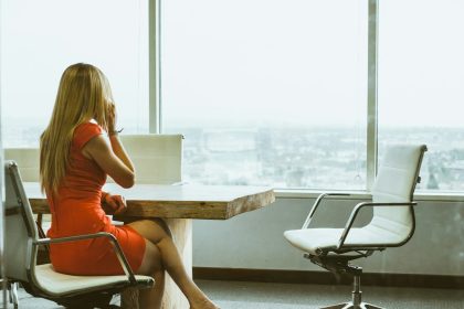 woman talking through mobile phone while sitting on swivel armchair